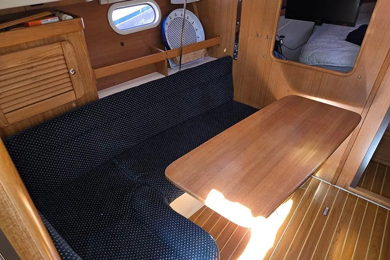 Slide: The Image of Interior of a 2005 Catalina 310 sailboat with wooden table and seating area. - 8
