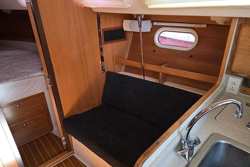 Slide: The Image of Interior of a 2005 Catalina 310 sailboat with seating, sink, and cozy cabin space. - 9