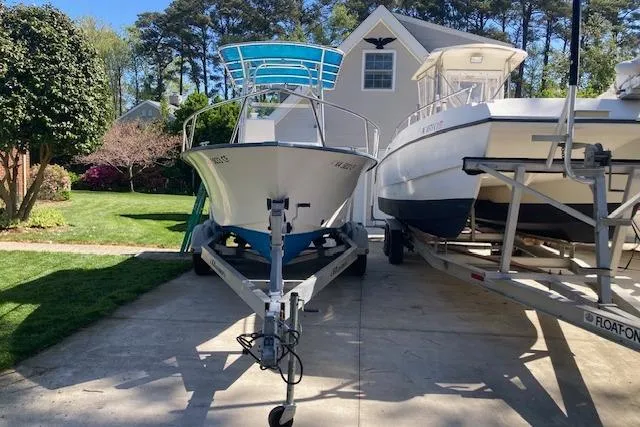 The Image of 2004 Palm Beach 205 cc boat parked in front of a suburban house. - 0