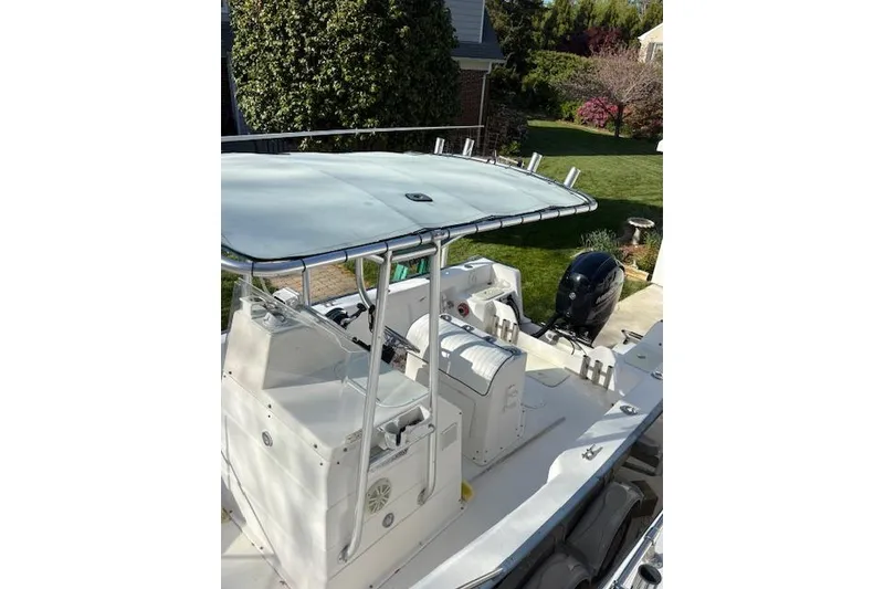 Slide: The Image of 2004 Palm Beach 205 cc boat with T-top and outboard motor in a driveway. - 14