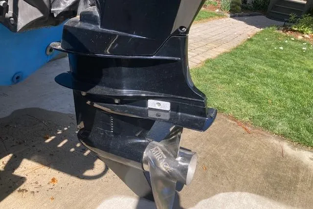 Slide: The Image of 2004 Palm Beach 205 cc boat with steering console and seating, docked outdoors. - 2