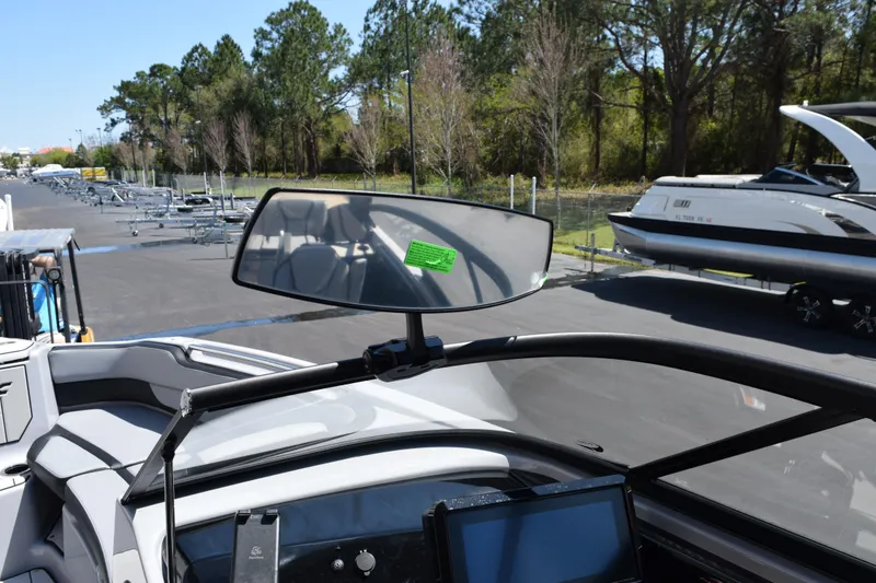 Slide: The Image of 2026 Yamaha Boats 255XD dashboard view with windshield and digital display in a marina setting. - 16