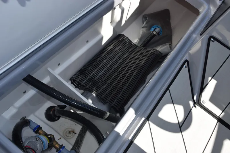 Slide: The Image of Interior compartment of 2026 Yamaha Boats 255XD, showcasing storage and hose system. - 23