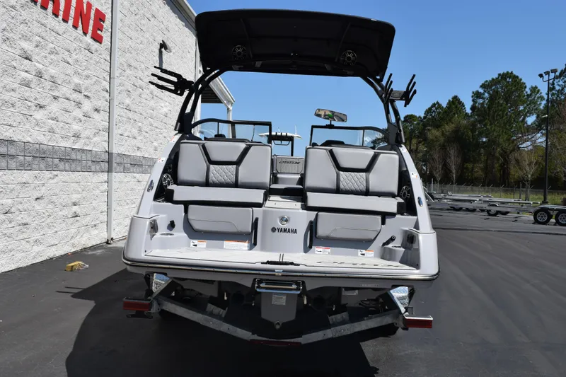 Slide: The Image of 2026 Yamaha Boats 255XD, rear view, parked outdoors, showcasing sleek design and seating. - 5