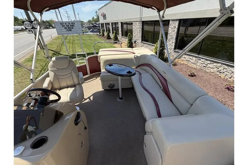 Slide: The Image of 2012 Sweetwater Premium Edition 220 DL pontoon boat interior with plush seating and steering console. - 14