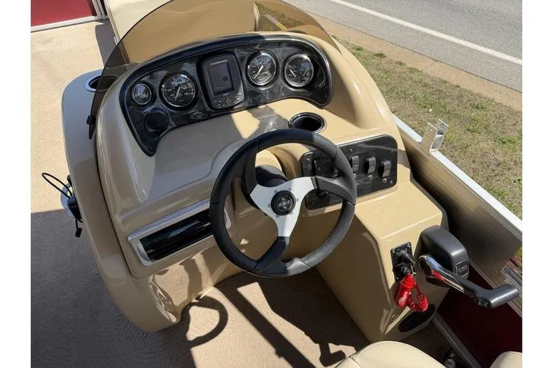 Slide: The Image of 2012 Sweetwater Premium Edition 220 DL boat dashboard with steering wheel and control panel. - 16