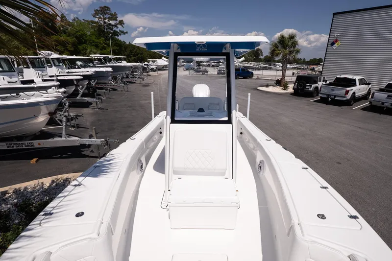 Slide: The Image of 2026 Blazer Bay Makaira 2600 boat displayed at a dealership, surrounded by other boats. - 12