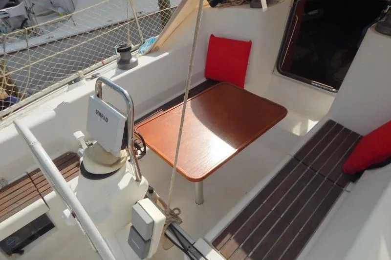Slide: The Image of Cockpit of 1997 Etap 38i sailboat with wooden table and red cushions. - 13