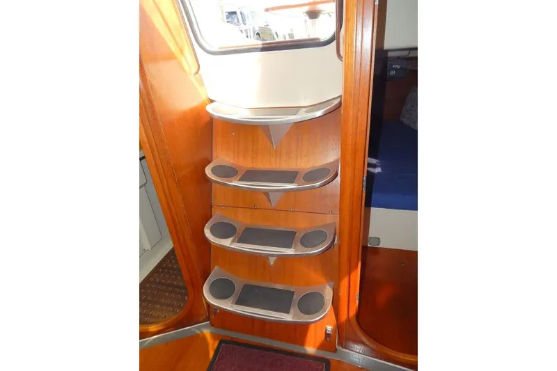 Slide: The Image of Interior of a 1997 Etap 38i sailboat featuring wooden steps and storage shelves. - 14