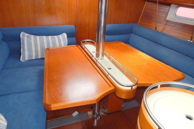 Slide: The Image of Interior of a 1997 Etap 38i sailboat with wooden table and blue seating. - 15