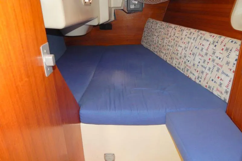 Slide: The Image of Interior cabin of a 1997 Etap 38i sailboat with blue cushions and wooden paneling. - 16