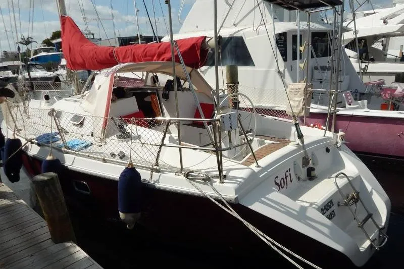 Slide: The Image of 1997 Etap 38i sailboat docked, featuring red sail cover and white hull. - 2