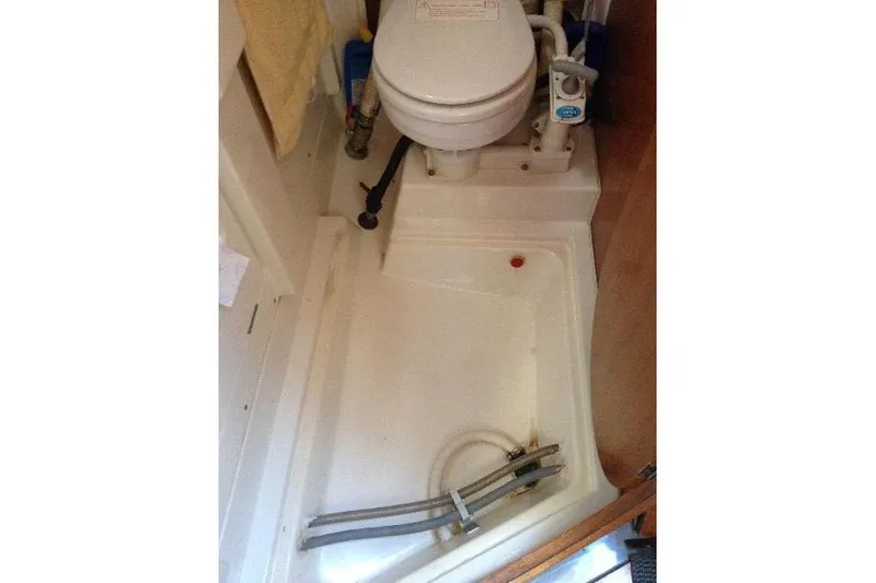 Slide: The Image of Bathroom interior of a 1997 Etap 38i yacht, featuring a compact marine toilet. - 23