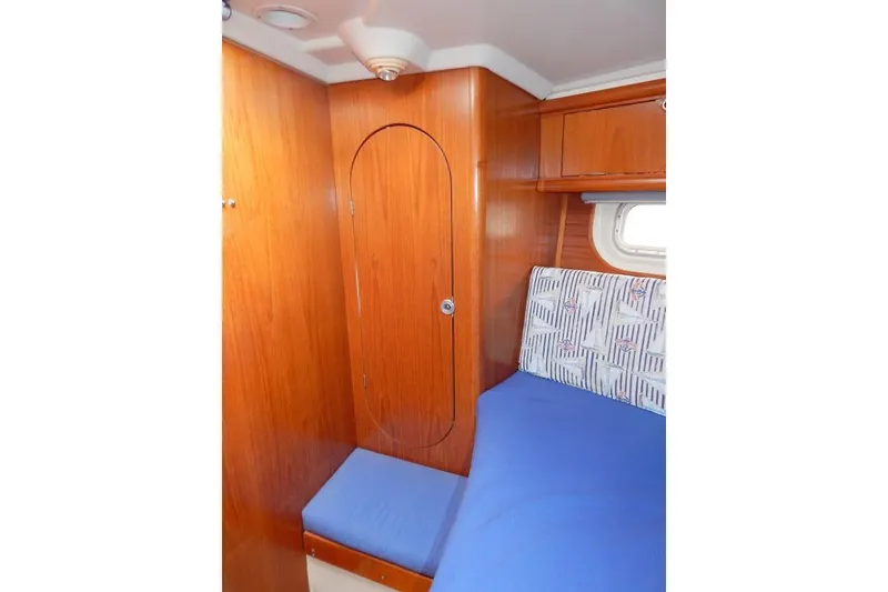 Slide: The Image of Cozy cabin interior of a 1997 Etap 38i sailboat with wooden paneling and blue bedding. - 35