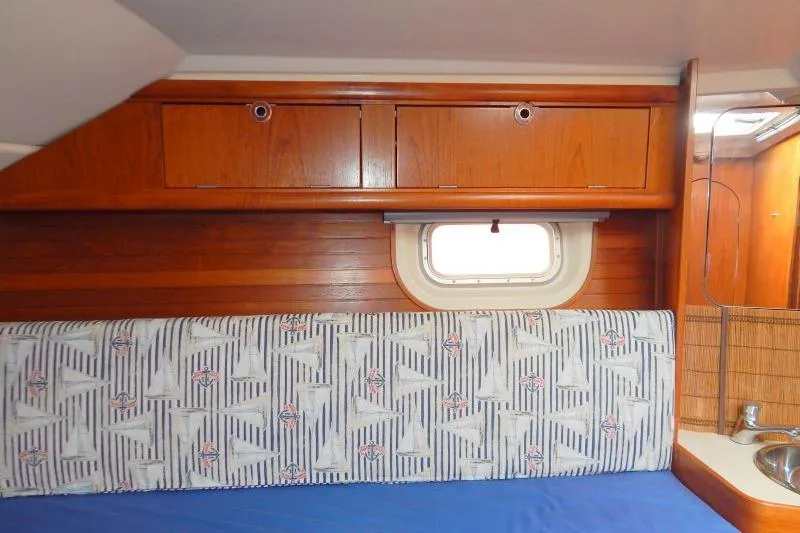 Slide: The Image of Interior of a 1997 Etap 38i sailboat with wooden cabinets and nautical-themed upholstery. - 38