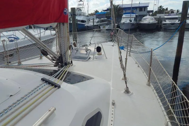 Slide: The Image of 1997 Etap 38i sailboat deck view at marina, featuring rigging and safety netting. - 8