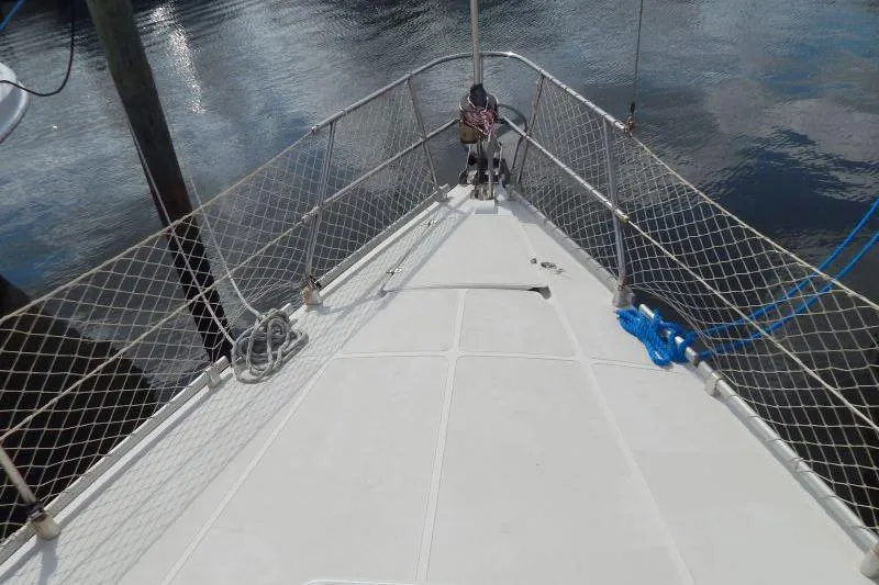 Slide: The Image of Bow view of 1997 Etap 38i sailboat with netted railings and docked in calm waters. - 9