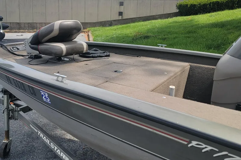 Slide: The Image of 2005 Tracker Pro Team 175 boat on trailer, featuring seating and deck, parked outdoors. - 11
