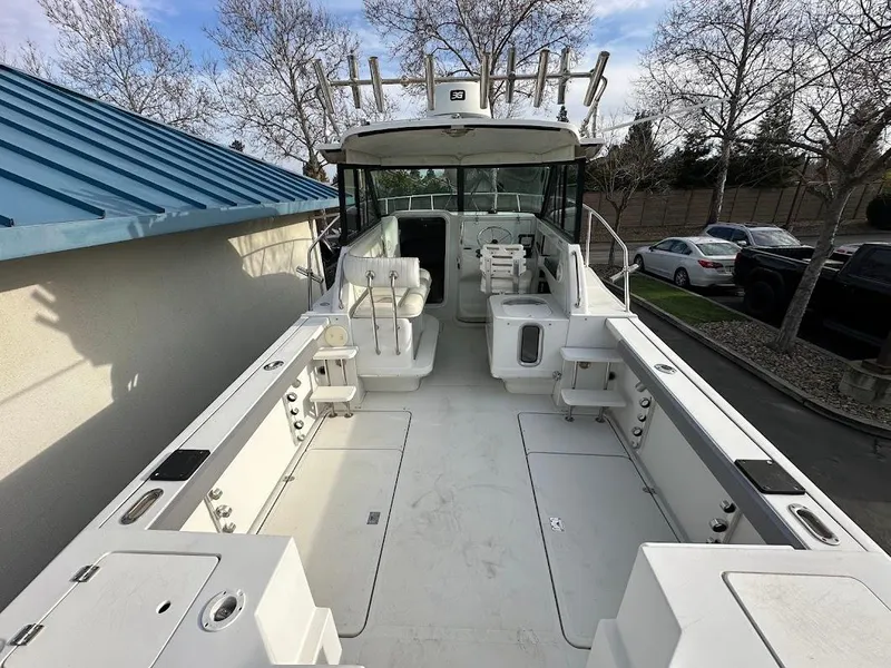 Slide: The Image of Glacier Bay 2680 Coastal Runner 2000, spacious deck, docked beside blue roof. - 14