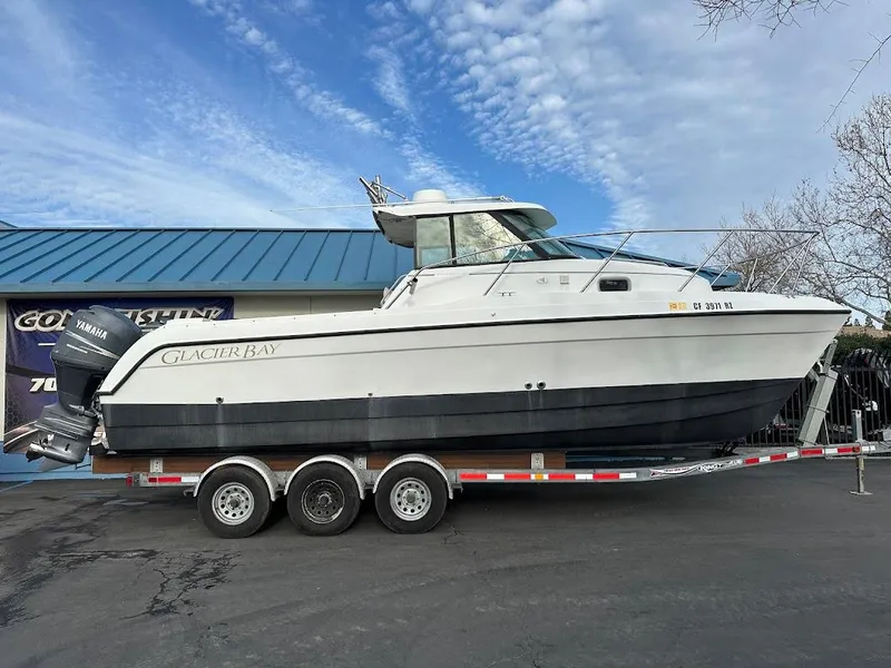 The Image of 2000 Glacier Bay 2680 Coastal Runner on trailer in front of blue building. - 2