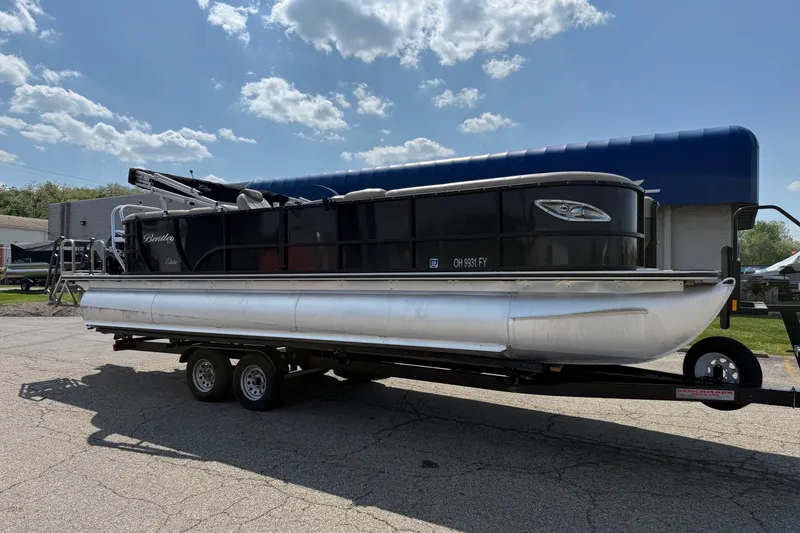 The Image of 2020 Bentley Pontoons 253 Elite Admiral on trailer under blue sky. - 0