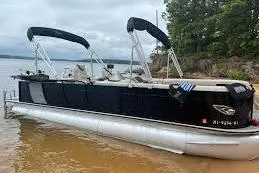 The Image of 2020 Bentley Pontoons 253 Elite Admiral on a calm lake with lush greenery. - 1