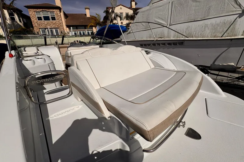 Slide: The Image of 2012 Formula 290 Sun Sport boat with white seating, docked near waterfront homes. - 11