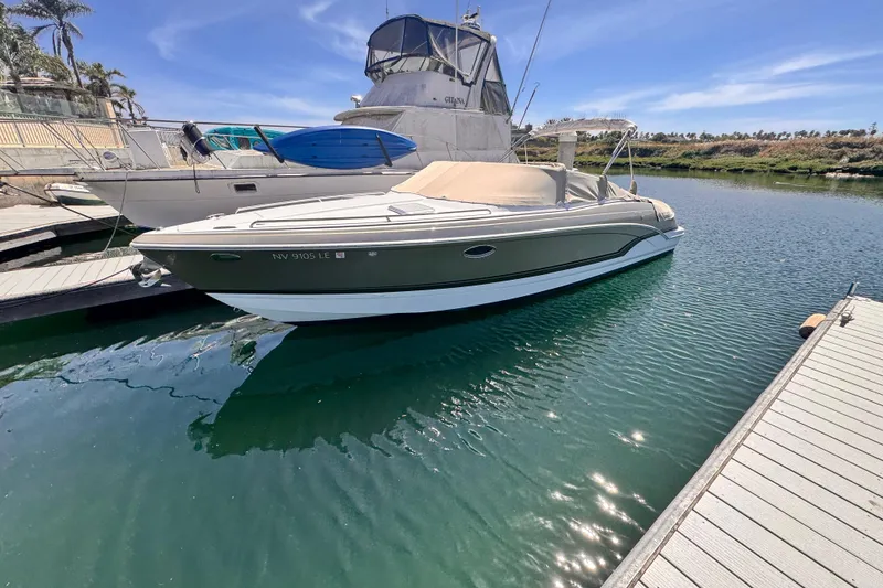Slide: The Image of 2012 Formula 290 Sun Sport boat docked in a marina with coastal homes in the background. - 3