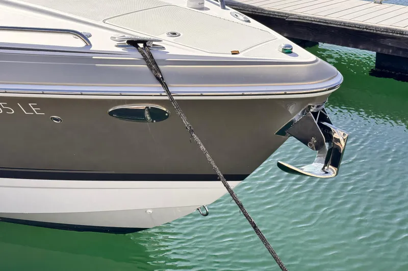 Slide: The Image of 2012 Formula 290 Sun Sport boat anchored at a marina, showing sleek design and chrome anchor. - 45