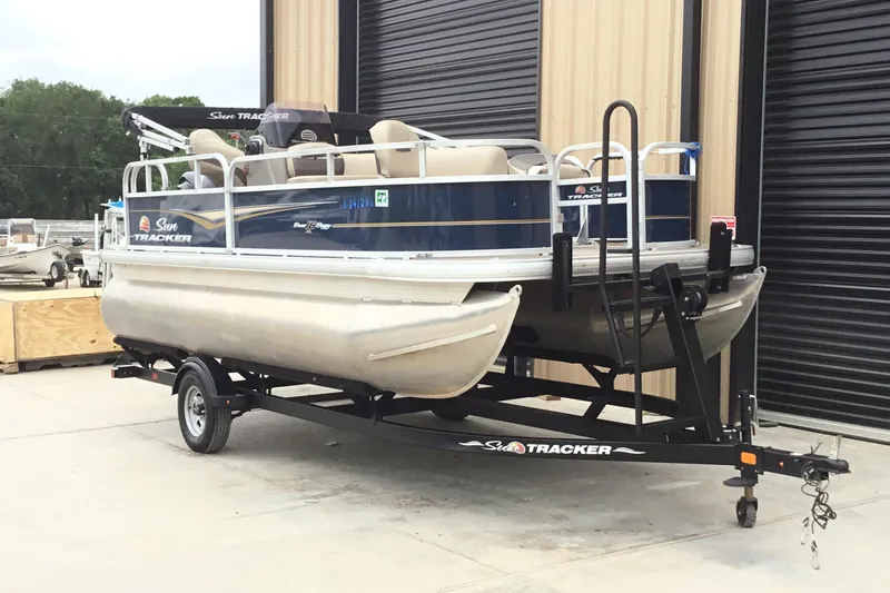 Slide: The Image of 2022 Sun Tracker Bass Buggy 16 XL pontoon boat on trailer, parked outdoors. - 3