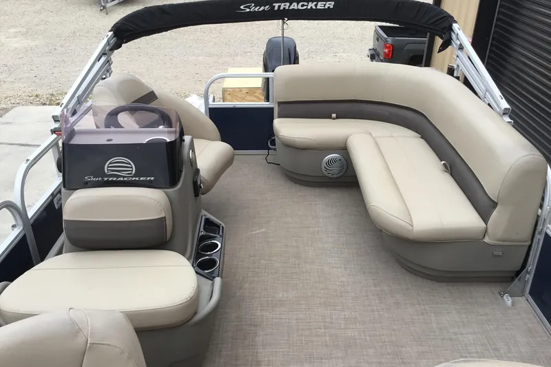 Slide: The Image of 2022 Sun Tracker Bass Buggy 16 XL pontoon boat interior with beige seating and steering console. - 6
