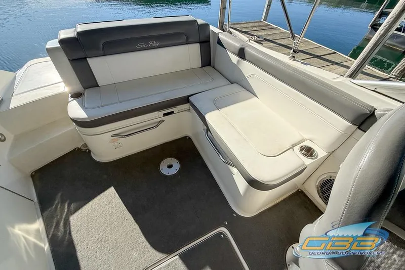 Slide: The Image of 2011 Sea Ray 260 Sundeck interior seating with gray upholstery and cup holder. - 11