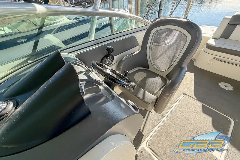 Slide: The Image of 2011 Sea Ray 260 Sundeck cockpit with steering wheel and comfortable seating. - 13