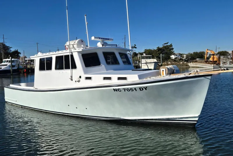 The Image of 1995 MDI Down East boat docked in a marina under clear blue skies. - 1