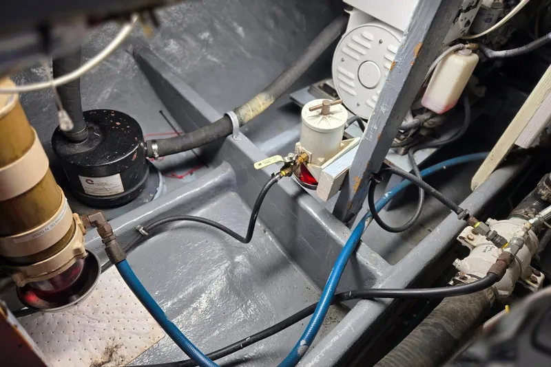 Slide: The Image of Engine compartment of a 1995 MDI Down East boat, showcasing hoses and mechanical components. - 10