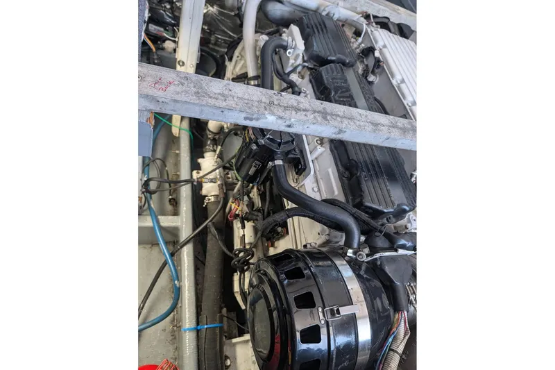 Slide: The Image of Engine compartment of a 1995 MDI Down East boat, showcasing mechanical components and wiring. - 13