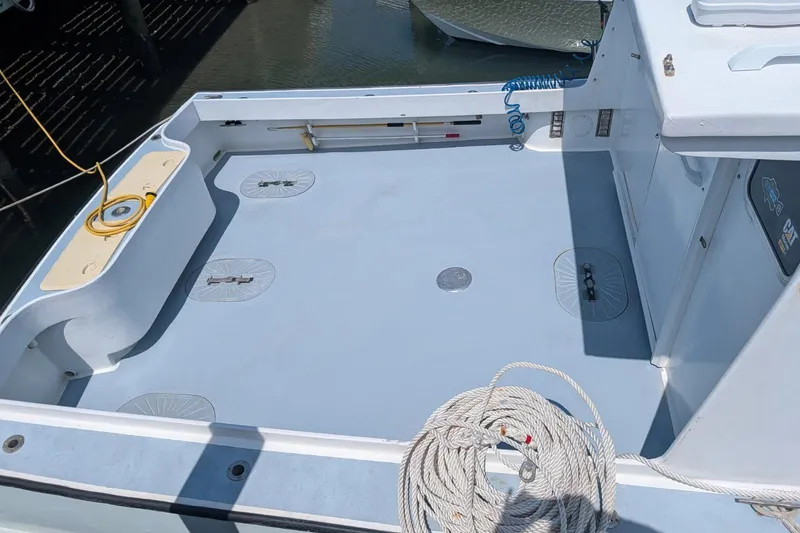 Slide: The Image of 1995 MDI Down East boat deck with ropes and cleats, docked by the water. - 3