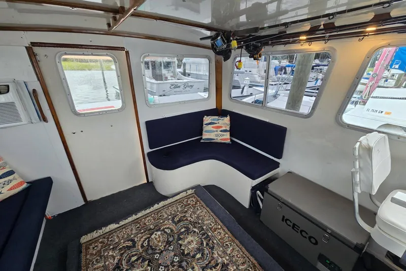 Slide: The Image of Interior of a 1995 MDI Down East boat with seating, windows, and nautical decor. - 5
