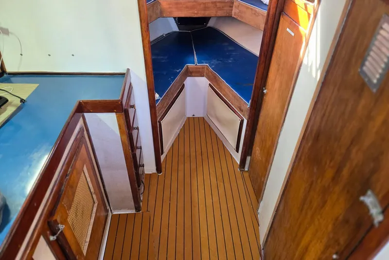 Slide: The Image of Interior of a 1995 MDI Down East boat with wooden flooring and blue accents. - 6