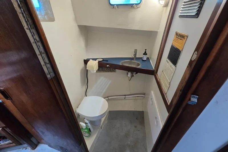 Slide: The Image of Compact boat bathroom with sink, toilet, and wooden accents in a 1995 MDI Down East model. - 7