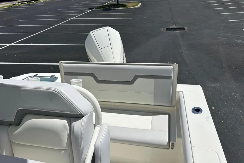 Slide: The Image of 2026 Mako 226 Center Console boat interior with white seating in a parking lot. - 6
