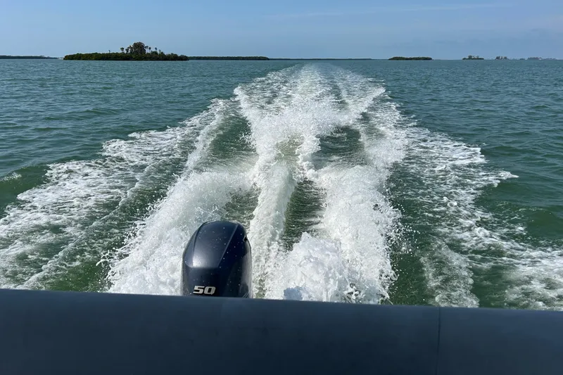 Slide: The Image of Wake trail behind 2021 Godfrey Sweetwater 1880 CX boat on open water. - 19