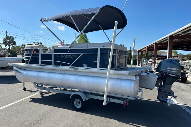 Slide: The Image of 2021 Godfrey Sweetwater 1880 CX pontoon boat with Yamaha outboard motor on trailer. - 4