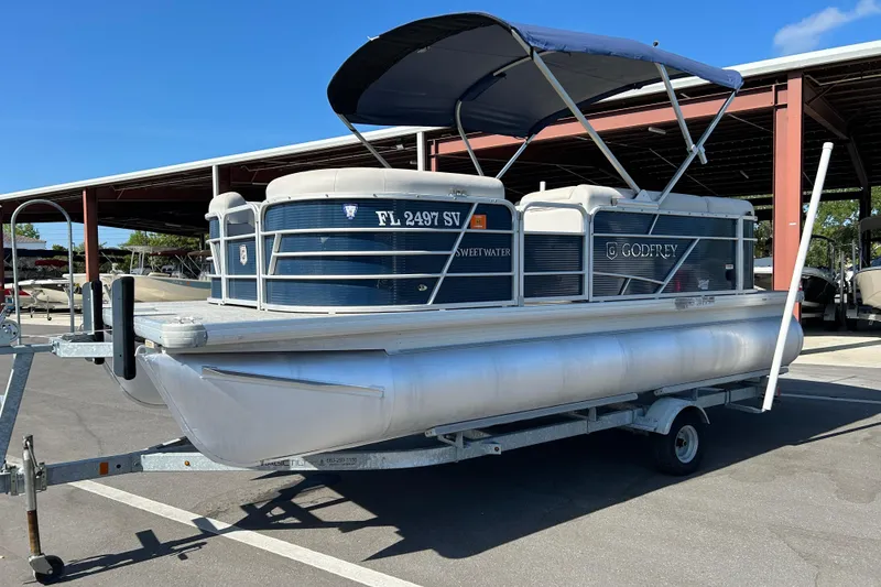 Slide: The Image of 2021 Godfrey Sweetwater 1880 CX pontoon boat on trailer in parking lot. - 5