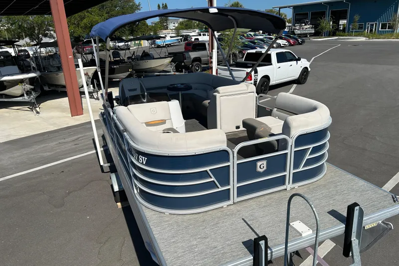 Slide: The Image of 2021 Godfrey Sweetwater 1880 CX pontoon boat with canopy in a parking lot. - 6