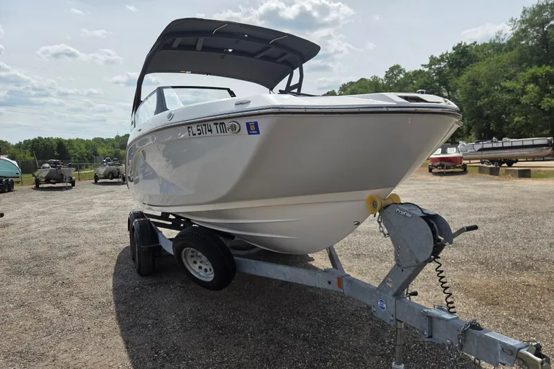 Slide: The Image of 2023 Yamaha Boats 222S on trailer, parked outdoors under a cloudy sky. - 2