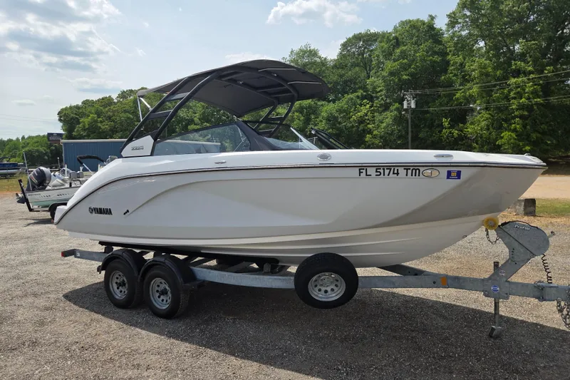 Slide: The Image of 2023 Yamaha Boats 222S on trailer, parked outdoors with trees in background. - 3