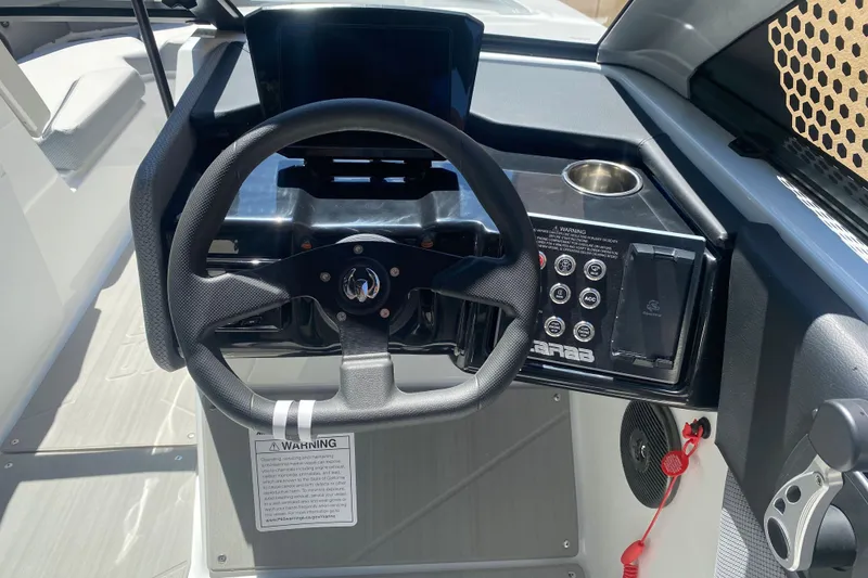 Slide: The Image of Steering wheel and dashboard of 2025 Scarab 235 SE boat, featuring modern controls and design. - 13