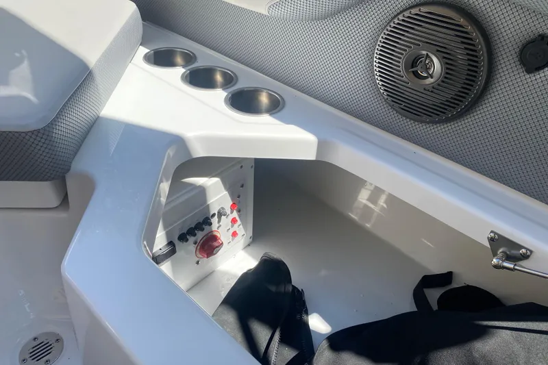 Slide: The Image of Interior of 2025 Scarab 235 SE boat featuring cup holders and control panel. - 20