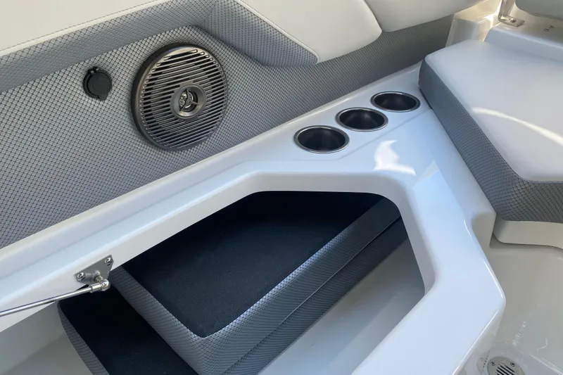 Slide: The Image of Interior of 2025 Scarab 235 SE boat featuring speaker, cup holders, and cushioned seating. - 21